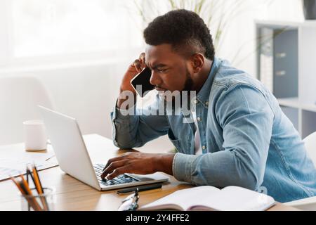 Besorgt Geschäftsmann mit Mobiltelefon und Laptop Bildschirm Stockfoto