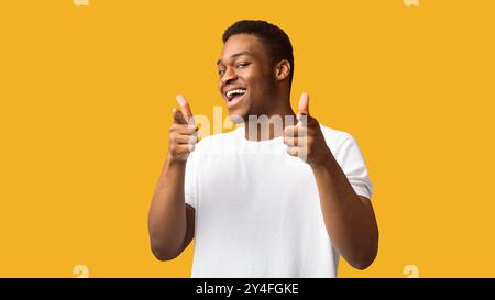 Happy afro Kerl, den Sie wählen über orange Hintergrund Stockfoto