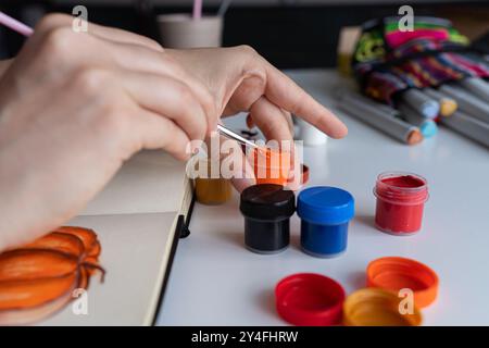 Künstler mischt Orange Gouache für Stockfoto