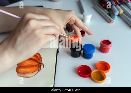 Künstler mischt Orange Gouache für Stockfoto