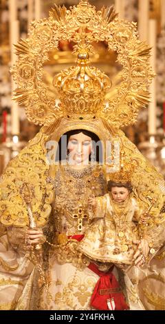 Aason, Spanien, 28. September 2010, die mit Gold gekrönte Marienstatue, die ein Kind hält, ist auf einem kunstvollen Altar mit Kerzen ausgestellt. Stockfoto