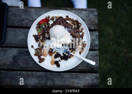 Einfacher hausgemachter Brownie- oder Schokoladenkuchen. Löffel Eis auf einem frischen Stapel frischer Brownies. Stockfoto