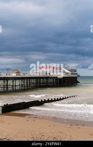 Blick vom Meer auf den Pier unter einem dunklen, bewölkten Himmel. Cromer, Norfolk, East Anglia, England, Vereinigtes Königreich, Großbritannien Stockfoto