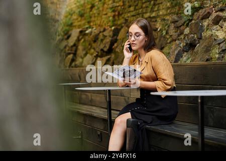 Eine junge Frau mit einer Beinprothese spricht am Telefon, während sie in einem ruhigen Café eine Speisekarte ansieht. Stockfoto