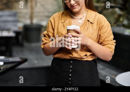Eine junge Frau in einem gemütlichen Café, die ihren Kaffee genießt und ihren dynamischen Lebensstil präsentiert Stockfoto