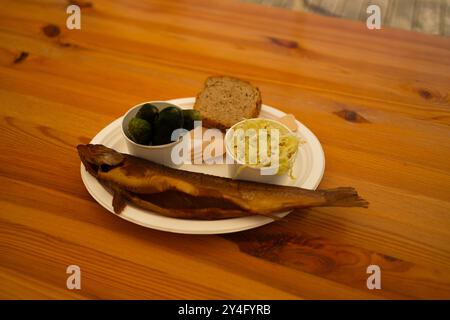 Gegrillter Thunfisch im Restaurant. Glücklicher Mann mit gegrilltem Seebarschfisch und anderen Gerichten in einem Fischrestaurant. Stockfoto