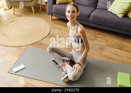 Die junge Frau mit Anorexie nimmt zu Hause ihre Fitness-Routine wahr, umgeben von einem warmen und einladenden Wohnraum. Stockfoto