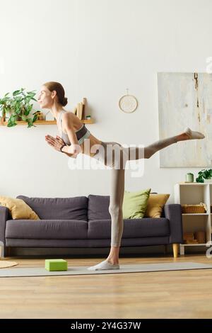 Eine junge Frau mit Anorexie betreibt zu Hause eine fokussierte Yoga-Praxis, die täglich nach Kraft und Balance strebt. Stockfoto