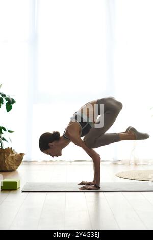 Eine junge Frau mit Anorexie nimmt zu Hause eine intensive Yoga-Pose ein, die Entschlossenheit und Fokus auf ihrer Wellness-Reise widerspiegelt. Stockfoto