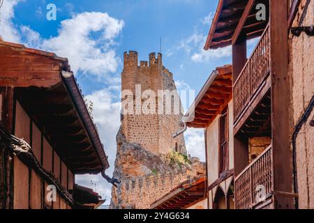 Frías, Spanien. August 2024. Beeindruckender Blick auf einen Verteidigungsturm, der über den traditionellen Gebäuden der Stadt hängt Stockfoto