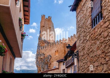 Frías, Spanien. August 2024. Beeindruckender Blick auf einen Verteidigungsturm, der über den traditionellen Gebäuden der Stadt hängt Stockfoto