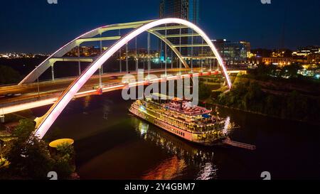 Blick aus der Vogelperspektive auf die beleuchtete Brücke und das Flussboot in Nashville Nachtleben Stockfoto