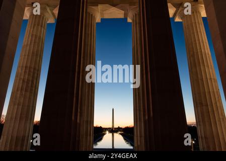 WASHINGTON DC, Vereinigte Staaten – das Washington Monument, die Kuppel des US Capitol und der Reflecting Pool vom Lincoln Memorial aus gesehen bei Sonnenaufgang während der Frühlings- und Herbstnachtgleiche. Die Sonne geht perfekt auf die National Mall auf und strahlt ein warmes Leuchten über die berühmten Wahrzeichen. Stockfoto