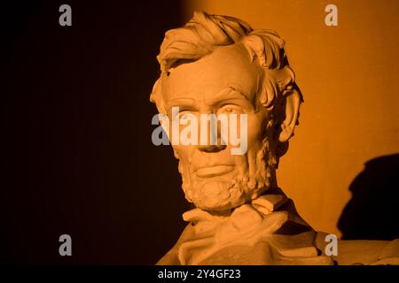 WASHINGTON DC, USA – die Statue von Abraham Lincoln im Lincoln Memorial wird kurz nach Sonnenaufgang von natürlichem goldenem Sonnenlicht beleuchtet. Dieser Lichteffekt, der rund um die Frühlings- und Herbstnachtgleiche sichtbar ist, unterstreicht die Pracht des Denkmals, wenn die Sonne durch den östlichen Eingang scheint. Das Lincoln Memorial befindet sich in der National Mall und ist eines der berühmtesten Denkmäler der USA. Hinweis: Farbe und Beleuchtung sind natürlich. Stockfoto