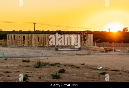 Einfamilienhaus mit Plattenfundamenten und dimensionalen Holzrahmen und Rahmen, die die Struktur des Hauses bei Sonnenuntergang in Georgetown Texas schaffen Stockfoto