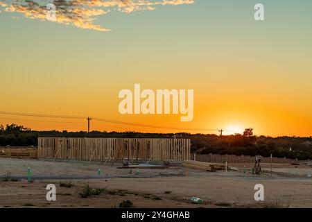 Einfamilienhaus mit Plattenfundamenten und dimensionalen Holzrahmen und Rahmen, die die Struktur des Hauses bei Sonnenuntergang in Georgetown Texas schaffen Stockfoto