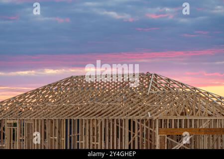 Einfamilienhaus mit Plattenfundamenten und dimensionalen Holzrahmen und Dachfachwerkrahmen, die die Struktur eines Hauses bei Sonnenuntergang in Georgetown schaffen Stockfoto