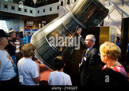 National Air and Space Museum Mercury 7 Capsule Washington DC // WASHINGTON DC – Besucher des National Air and Space Museum hören einem Reiseleiter zu, der das Mercury 7 Wiedereintrittsfahrzeug erklärt, die Kapsel, die John Glenn, den ersten Amerikaner, der die Erde 1962 sicher ins All umkreiste, transportierte. Diese historische Raumsonde ist ein Herzstück der Raumfahrt-Exponate des Museums. Stockfoto