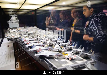 WASHINGTON DC, USA — Museumsbesucher untersuchen ein detailliertes Modell des Flugzeugträgers USS Enterprise im National Air and Space Museum des Smithsonian. Das Modell demonstriert die komplexe Architektur und Betriebsfähigkeit eines der bedeutendsten Schiffe der US Navy. Dieses Ausstellungsstück hilft den Besuchern, die Beziehung zwischen Luftfahrt- und Marineoperationen zu verstehen. Stockfoto