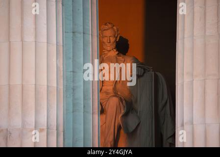 WASHINGTON DC, USA – die Statue von Abraham Lincoln im Lincoln Memorial wird kurz nach Sonnenaufgang von natürlichem goldenem Sonnenlicht beleuchtet. Dieser Lichteffekt, der rund um die Frühlings- und Herbstnachtgleiche sichtbar ist, unterstreicht die Pracht des Denkmals, wenn die Sonne durch den östlichen Eingang scheint. Das Lincoln Memorial befindet sich in der National Mall und ist eines der berühmtesten Denkmäler der USA. Stockfoto