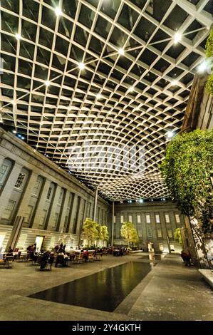 WASHINGTON DC – der Robert and Arlene Kogod Courtyard im Donald W. Reynolds Center for American Art and Portraiture des Smithsonian, beleuchtet bei Nacht mit dunklem Himmel, sichtbar durch seine unverwechselbare Glasdecke. Dieser 2007 von Foster + Partners entworfene, 000 Quadratmeter große überdachte Innenhof verbindet das Smithsonian American Art Museum und die National Portrait Gallery. Der elegante Innenraum mit einem gewellten Glasdach ist ein beliebter öffentlicher Treffpunkt im Zentrum von Washington, DC. Stockfoto