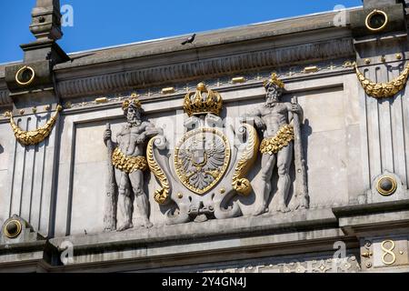 Detail der kunstvollen Skulpturen und des Wappens am Brama Wyżynna (Hochtor) in Danzig, Polen, mit Renaissance-Architektur und goldenen Akzenten. Stockfoto