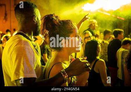 Ein junges gemischtes ethnisches Paar in einer Menge italienischer Leute, das ein kostenloses Nachtkonzert auf dem Platz in Depressa, einem Dorf in Apulien, freudet. Stockfoto