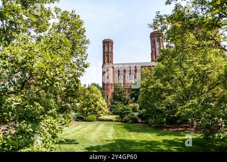 WASHINGTON DC, Vereinigte Staaten — das Smithsonian Castle, das hier vom Moongate Garden aus gesehen wird, wurde 1855 fertiggestellt und dient als Verwaltungssitz der Smithsonian Institution. Das vom Architekten James Renwick Jr. im Stil des Norman Revival entworfene Gebäude ist aus rotem Sandstein aus Seneca Creek, Maryland, gebaut. Das Schloss ist an der Südseite der National Mall verankert und beherbergt eine Dauerausstellung über die Geschichte und Sammlungen des Smithsonian. Stockfoto