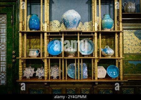 WASHINGTON DC – Blaue Töpferwaren und Teller werden auf den vergoldeten Regalen des Peacock Room in der Freer Gallery of Art ausgestellt Der Raum mit dem offiziellen Titel Harmony in Blue and Gold: The Peacock Room ist James McNeill Whistlers Meisterwerk der Inneneinrichtung, das zwischen 1876 und 1877 geschaffen wurde. Ursprünglich für den Londoner Speisesaal des Liverpool-Reedermagnaten Frederick Leyland entworfen, zeigt der Raum Whistlers revolutionäre Verwendung von preußischer blauer Farbe und niederländischer Metallvergoldung. Der Raum beherbergt etwa 250 Keramikstücke aus der Freer-Sammlung, die Werke aus Syrien, Iran, Japan und Chin darstellen Stockfoto