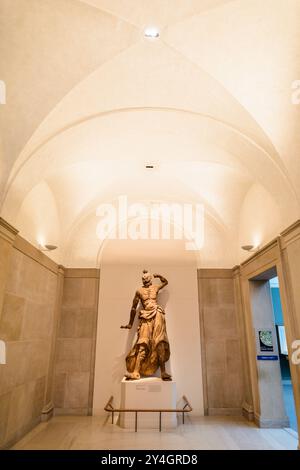 WASHINGTON DC, USA – Eine hölzerne Kriegerstatue in einem Korridor der Freer Gallery of Art in der National Mall. Diese beeindruckende Skulptur, Teil der asiatischen Kunstsammlung der Smithsonian Institution, zeigt die Handwerkskunst und kulturelle Bedeutung von Kriegerfiguren in asiatischen Kunsttraditionen vor dem Hintergrund der eleganten Innenarchitektur der Galerie. Stockfoto