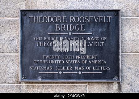 Theodore Roosevelt Bridge Plaque Washington DC // WASHINGTON DC – Eine Gedenktafel markiert die Theodore Roosevelt Bridge, die den Potomac River zwischen Washington DC und Virginia überspannt. Der Bronzemarker weist darauf hin, dass die Brücke zu Ehren von Theodore Roosevelt, dem 26. Präsidenten der Vereinigten Staaten, benannt wurde. Die Inschrift beschreibt Roosevelt als „Statesman-Soldier-man of Letters“, was seine vielfältigen Beiträge zur amerikanischen Geschichte hervorhebt. Stockfoto