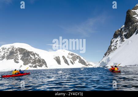 CUVERVILLE ISLAND, Antarktis – Kajakfahrer halten an, um die atemberaubende Landschaft an einem klaren, sonnigen Tag auf Cuverville Island auf dem antarktischen Peninsul zu bewundern Stockfoto