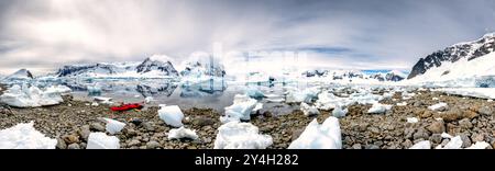 Ein hochauflösendes Panorama eines Kajaks an der felsigen Küste Cuverville Island auf der antarktischen Halbinsel hochgezogen. Stockfoto