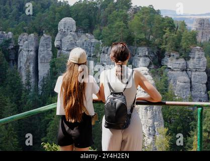 Zwei kaukasische Frauen von hinten mit Blick auf die Sandsteinstadt im Naturschutzgebiet Hruboskalsko Stockfoto