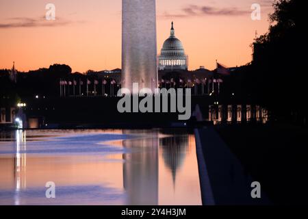 WASHINGTON DC, Vereinigte Staaten – das Washington Monument, die Kuppel des US Capitol und der Reflecting Pool vom Lincoln Memorial aus gesehen bei Sonnenaufgang während der Frühlings- und Herbstnachtgleiche. Die Sonne geht perfekt auf die National Mall auf und strahlt ein warmes Leuchten über die berühmten Wahrzeichen. Stockfoto