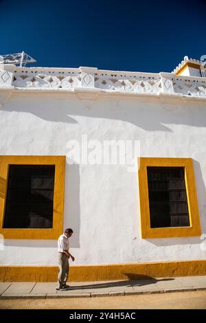 Sevilla, Spanien am 15. August 2007 spaziert Ein Mann nachdenklich entlang der hellen weißen Wände der echten Maestranza-Stierkampfarena in Sevilla unter einem klaren blauen Himmel. Stockfoto