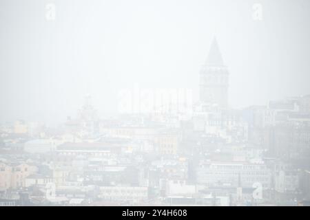 ISTANBUL, Türkei / Türkiye – die Silhouette des Galata-Turms taucht durch schweren Nebel auf, vom Topkapi-Palast aus gesehen. Diese stimmungsvolle Szene fängt ein Stockfoto