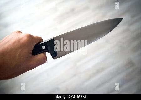 Bayern, Deutschland - 18. September 2024: Ein Mann hält ein großes Küchenmesser in der Hand. Symbolische Bildbedrohung oder -Gefahr durch Messer *** ein Mann hält ein großes Küchenmesser in der Hand. Symbolbild Bedrohung oder Gefahr durch Messer Stockfoto