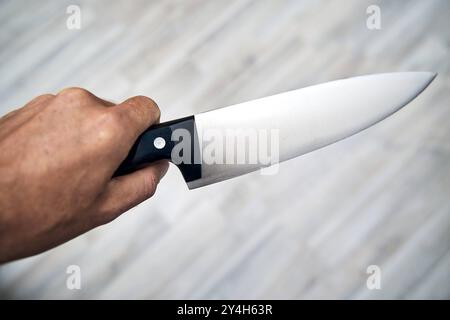 Bayern, Deutschland - 18. September 2024: Ein Mann hält ein großes Küchenmesser in der Hand. Symbolische Bildbedrohung oder -Gefahr durch Messer *** ein Mann hält ein großes Küchenmesser in der Hand. Symbolbild Bedrohung oder Gefahr durch Messer Stockfoto