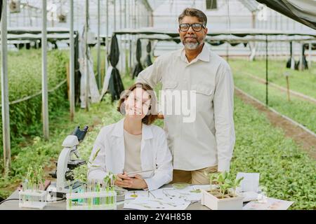 Lächelnde Kollegen im Gewächshauslabor Stockfoto