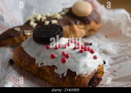 Nahaufnahme von einigen Schokoladen Blätterteiggebäck, dekoriert mit mehr Schokolade in verschiedenen Farben, ungesundes Essen mit viel Zucker Stockfoto