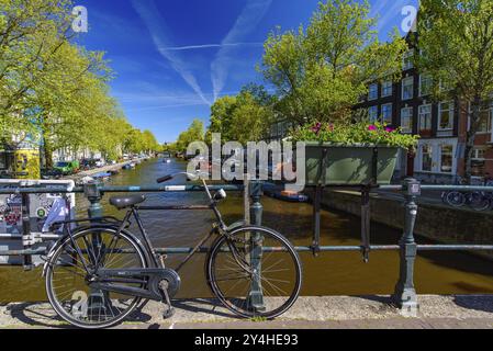 Fahrräder, die auf der Brücke, die den Kanal in Amsterdam, Niederlande, Kreuze Stockfoto