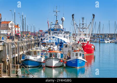 Scarborough Yorkshire. Blick auf den Hafen von Scarborough mit kleinen und großen, bunten Fischerbooten, die an der Hafenmauer ankern Stockfoto