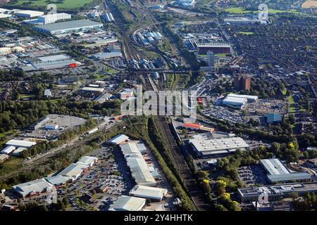 Aus der Vogelperspektive os Crewe mit Blick nach Süden entlang der Eisenbahn vom Grand Junction Retail Park & Tesco mit dem Bahnhof und verschiedenen Unternehmen im Hintergrund Stockfoto