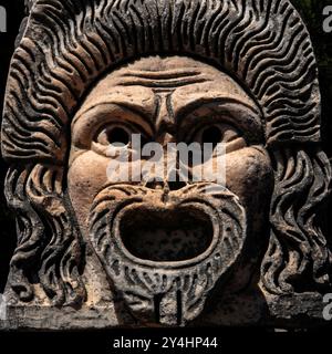 Römische Theatermaske, heute im römischen Theater in Ostia Antica, Italien, ausgestellt und einst Teil der architektonischen Dekoration des Theaters. Stockfoto