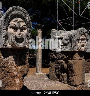 Ausstellung von Theatermasken im Theater in Ostia Antica, Italien. Diese Masken waren einst Teil der architektonischen Dekoration des Theaters. Stockfoto