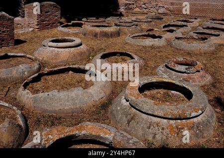 Basen von Dolia defossa oder vergrabenen Gläsern, die einst zur Lagerung von Wein oder Olivenöl verwendet wurden, im Lagerhaus der Dolia (Magazzino dei Doli oder Caseggiato dei Doli) in Ostia Antica, Italien. Stockfoto