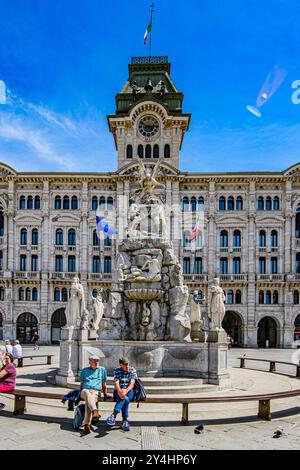 TRIEST, ITALIEN – 29. MAI 2024: Palazzo Comunale und der Brunnen der vier Kontinente auf der Piazza Unità d’Italia. Dieser legendäre Brunnen repräsentiert die Stockfoto