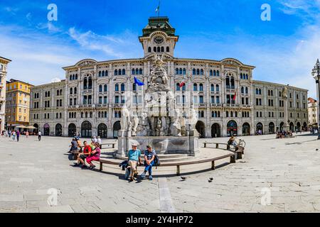 TRIEST, ITALIEN – 29. MAI 2024: Palazzo Comunale und der Brunnen der vier Kontinente auf der Piazza Unità d’Italia. Dieser legendäre Brunnen repräsentiert die Stockfoto