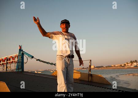 Sevilla, Spanien, 7. August 2008, Ein Seemann leitet geschickt Ein Binnenschiff, das Passagiere über den Fluss Guadalquivir in Sanlucar de Barrameda transportiert. Stockfoto